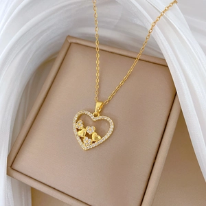Close-up of a gold heart pendant necklace with shimmering crystals and small inner hearts
