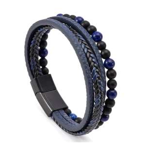 Detail of layered leather bracelet featuring tiger eye beads and black magnetic buckle