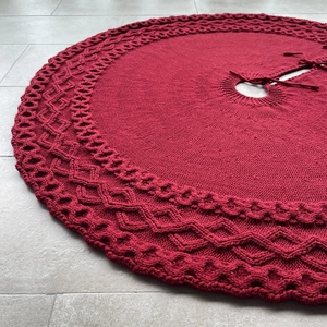 Detailed close-up of red cable knit Christmas tree skirt with decorative ribbon ties
