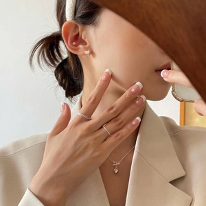 Detailed view of minimalist 925 silver heart earrings and matching jewelry set on model