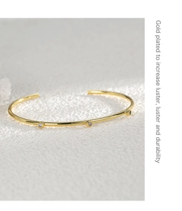 Detail of adjustable gold-plated brass bangle with three inset white zircon stones