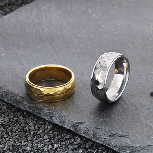 Hammered texture titanium steel rings in gold and silver finish on dark stone