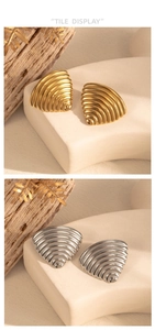 Detailed close-up of gold and silver fan-shaped ribbed earrings with metal texture