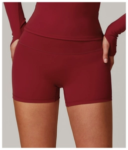 Dettaglio dei pantaloncini fitness a vita alta e maniche lunghe in rosso vino scuro