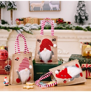 Detailed view of three burlap Christmas gnome gift bags with plush beards and ho ho text