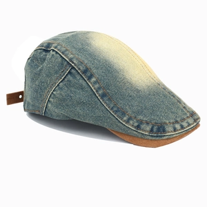 Detail view of washed denim ivy cap with brown leather brim and contrast stitching