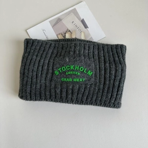 Details des dunkelgrauen Strick-Stirnbands mit grüner Stockholm Sweden Stickerei