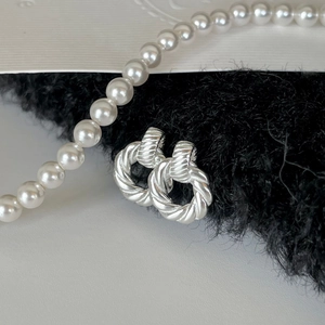 Minimalist S925 sterling silver twist hoop earrings displayed on black plush fabric