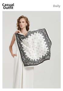 Detail of white square scarf with black paisley pattern and elegant wavy edges