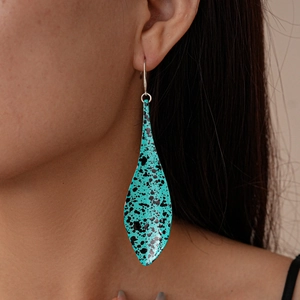 Bohemian leaf-shaped drop earring in turquoise blue with black splash on a female model