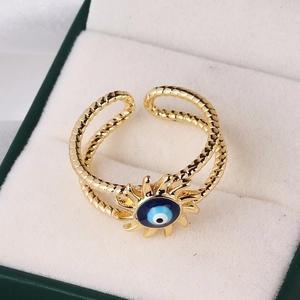 Macro view of blue zircon evil eye ring on beige velvet jewelry box tray