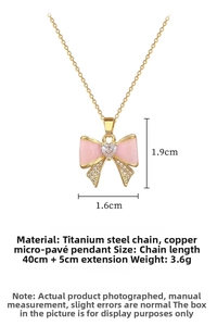 Detailed view of pink bow pendant with heart zircon, dimensions 1.9cm x 1.6cm on gold chain