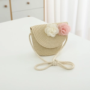 Detail of child straw crossbody bag with delicate white and pink 3D flower decorations