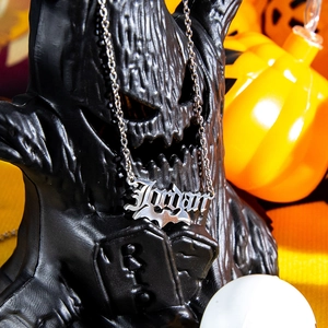 Macro detail of silver Jordan name pendant with a bat design for Halloween