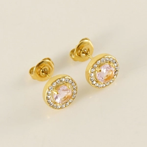 Détail de boucles d'oreilles dorées avec pierre rose centrale et halo de zircons clairs