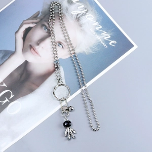 Silver bead chain necklace featuring a silver astronaut charm and a large metal ring detail