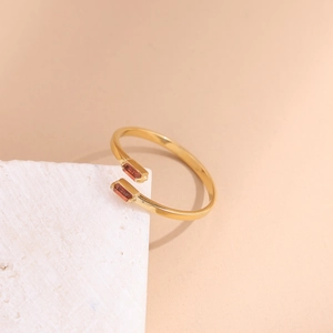 Detail of gold-plated open ring featuring two rectangular reddish-brown zircons