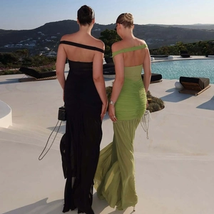 Detail view of backless mesh splice dresses in black and green at a poolside resort