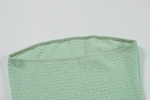 Vue macro détaillée du tissu froncé vert menthe haute élasticité et couture overlock fine
