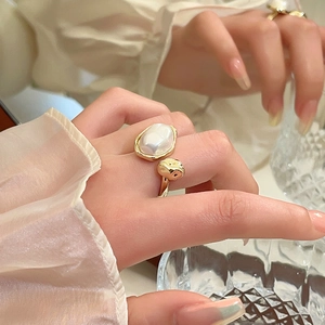 Detail of vintage irregular pearl open ring in gold plating on model's finger