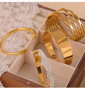 Detailed set of four 18K gold-plated titanium steel bracelets in a wooden jewelry box