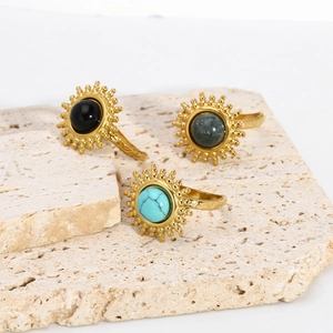 Détails de bagues vintage avec turquoise et pierres noires sur une base en travertin