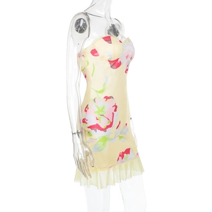 Détail de l'imprimé floral rose et de l'ourlet à volants d'une robe jaune courte