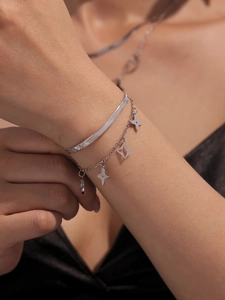Gros plan sur un bracelet argenté multicouche avec chaîne serpent et pendentifs étoiles