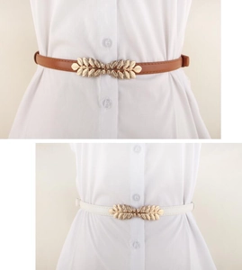 Detail of thin adjustable belts with golden leaf buckles in brown and white colors