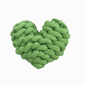 Hand-knotted green heart-shaped throw pillow with soft woven texture on white background