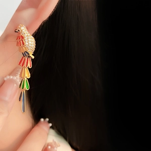 Close-up of luxury vintage parrot earrings with colorful gemstones and gold plating