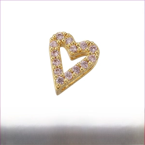 Macro detail of 7x8mm heart-shaped brass bead with pink zircon micro-inlay for DIY jewelry