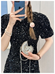 Chic silver conch shell mini bag with chain strap styled on a sequin dress for party