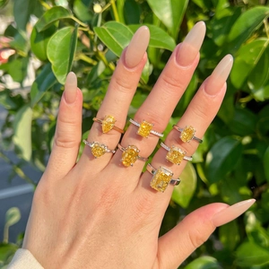 Multiple S925 sterling silver rings with yellow radiant cut gemstones on a hand