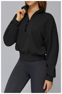 Detailed close-up of a black half-zip sports sweatshirt with ribbed cuffs and stand collar
