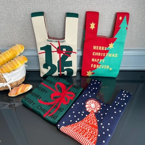 Détail de sacs à main de Noël en tricot rouge, vert et beige avec des motifs jacquard festifs