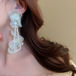 Détail des boucles d'oreilles fleurs en organza bleu clair avec perles de cristal