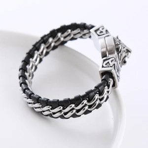 Macro shot of a stainless steel lion head buckle on a black braided leather motorcycle bracelet