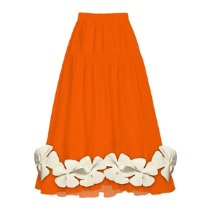 Detail of orange high waist swim skirt with 3D white flower appliqué on the hemline