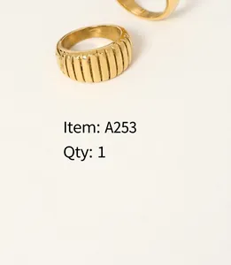 Macro detail of a gold-plated croissant ring with a rippled texture on a book page