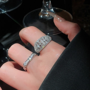 Close-up of stacked silver rings with bow design and shimmering cubic zirconia on model