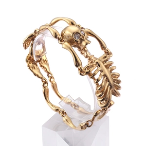 Gothic gold skeleton bone bracelet with rhinestone eyes shown at a 45-degree angle view