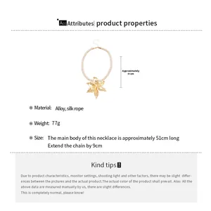 Detail view of large gold flower pendant necklace with thick beige silk rope cord