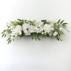 Detailed view of long floral arrangement with white roses and lush green leaves