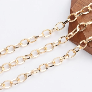 Detail of 18K gold plated cross oval link chains on wood surface for jewelry making