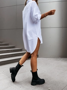 Detail of white oversized long-sleeve shirt with side slits and round hem in street style