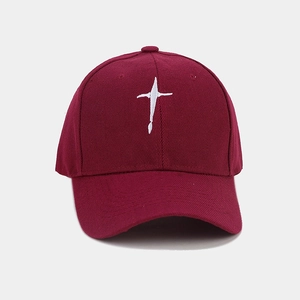 Gros plan détaillé de la casquette de baseball bordeaux avec broderie croix blanche