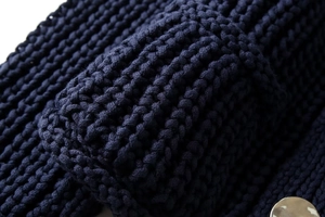 Gros plan détaillé sur un tissu en maille épaisse bleu foncé montrant la texture du tissage