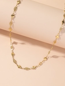 Detailed view of golden heart charms and textured oval links on a stainless steel necklace