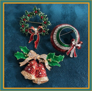 Detailed view of Christmas brooches with holly wreath and bells on blue velvet